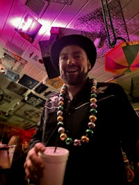 a man wearing a hat and beaded necklace